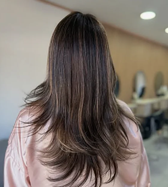 Pelo largo castaño con capas y mechas iluminadas, trabajo de Mef Hair Studio
